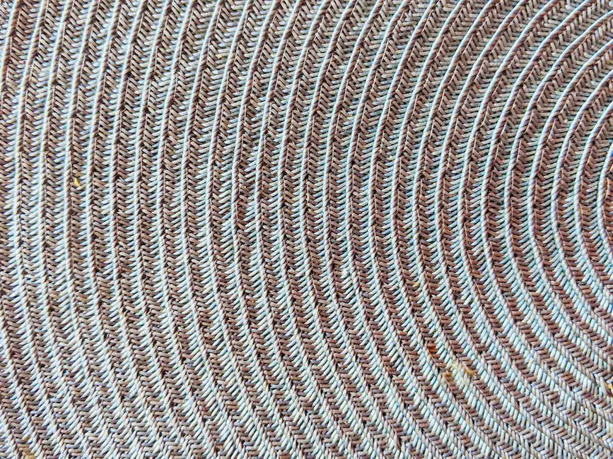 A close-up image of a carbon fiber deck with a woven pattern shining under the sun.