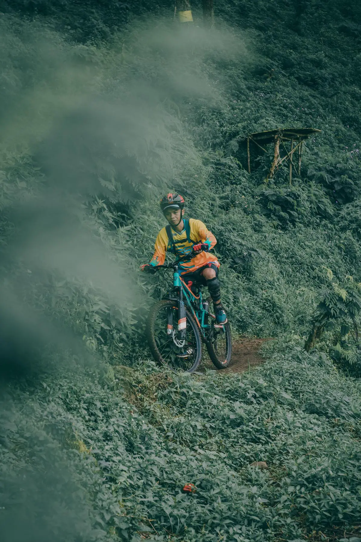 A person riding an e-mountain bike downhill on a rocky trail with the wind blowing in their face